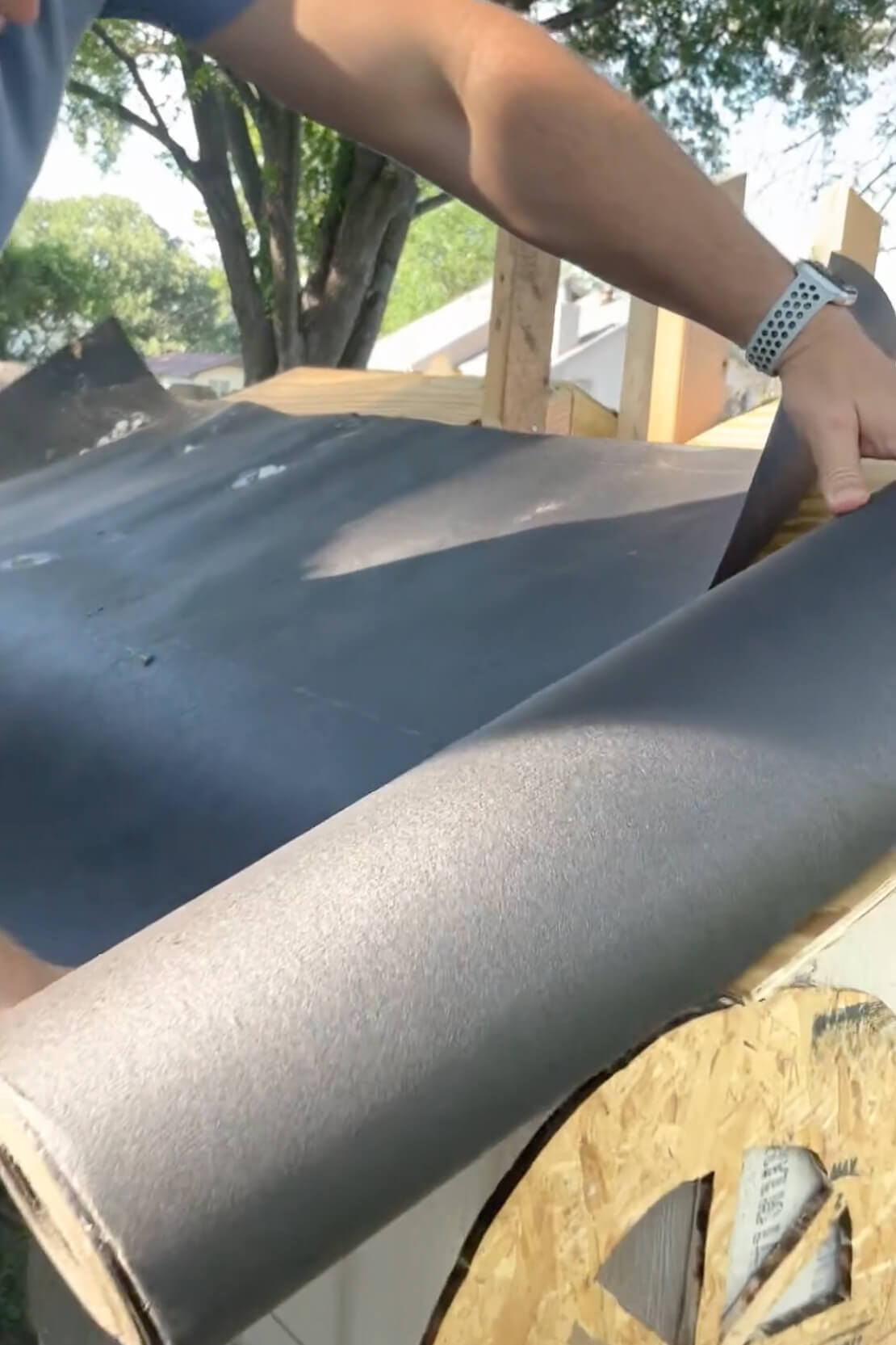 Using tar paper for roofing on low cost DIY chicken coop.